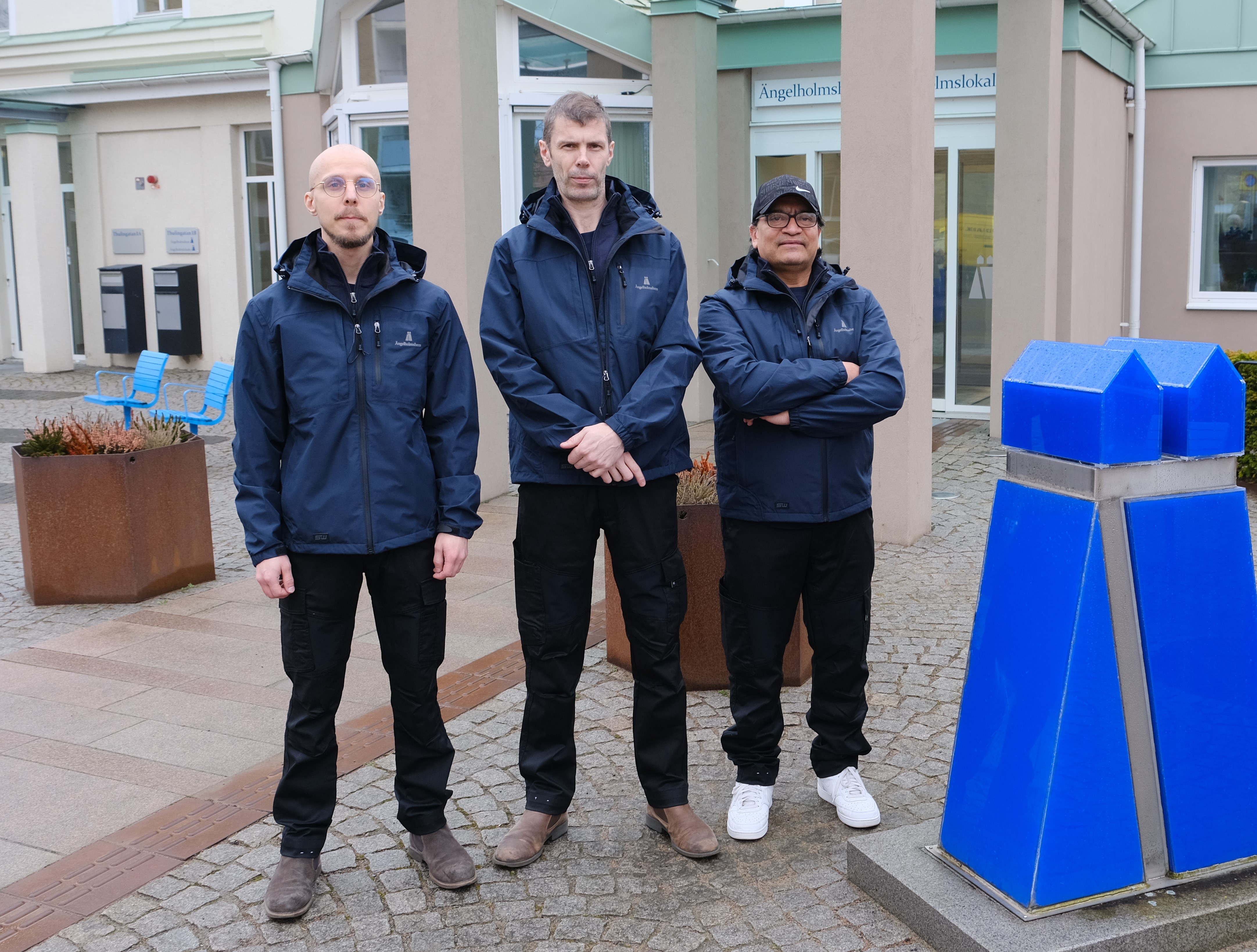 Tre personer står framför Ängelholmshems huvudkontor