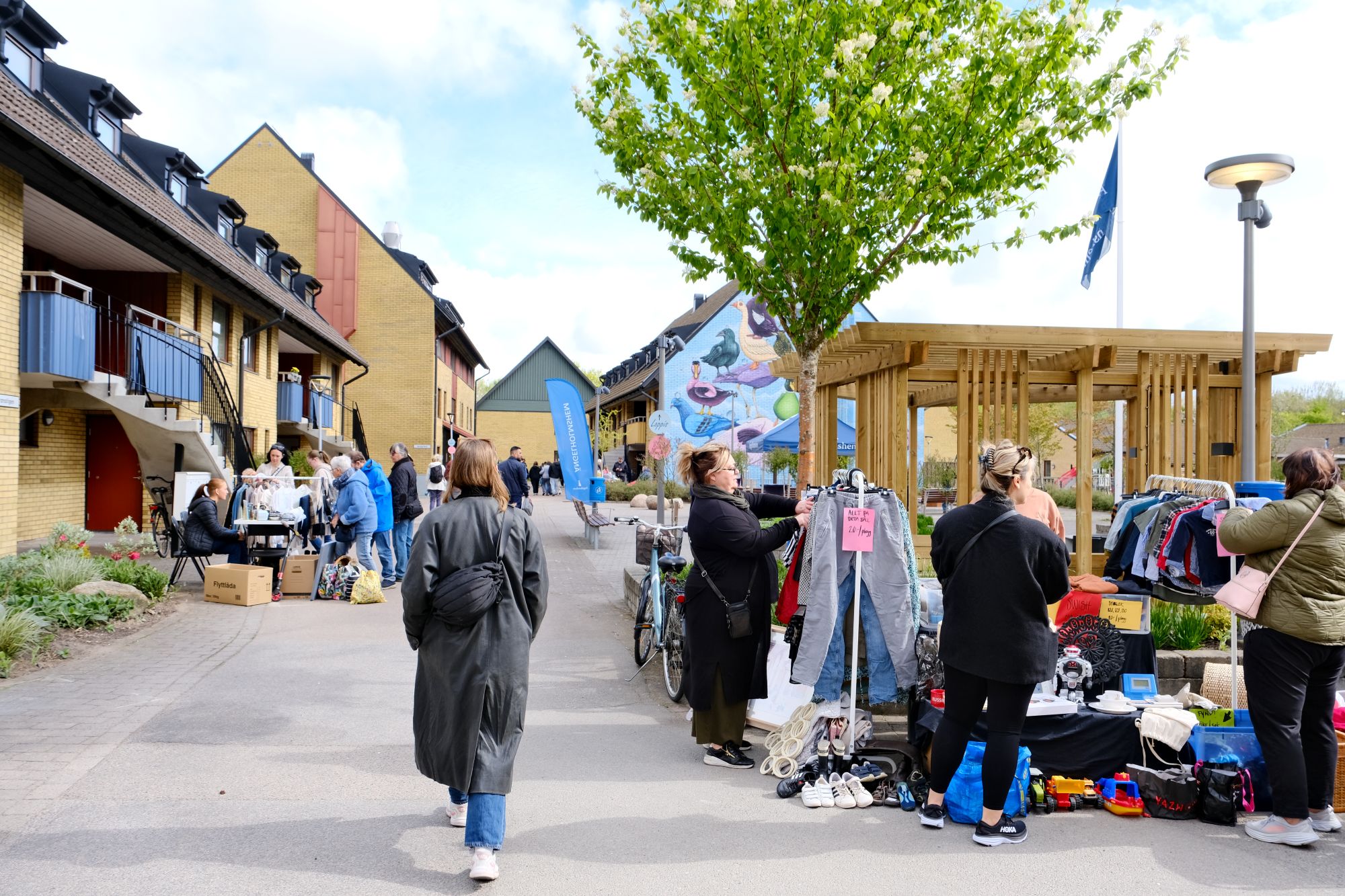 Loppissäljare står med bord längst en gångväg
