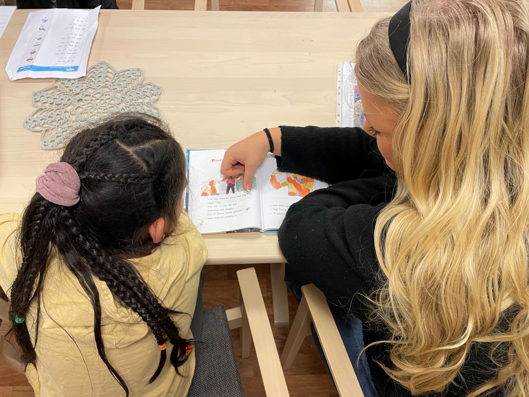 En flicka och en mentor övar läsning