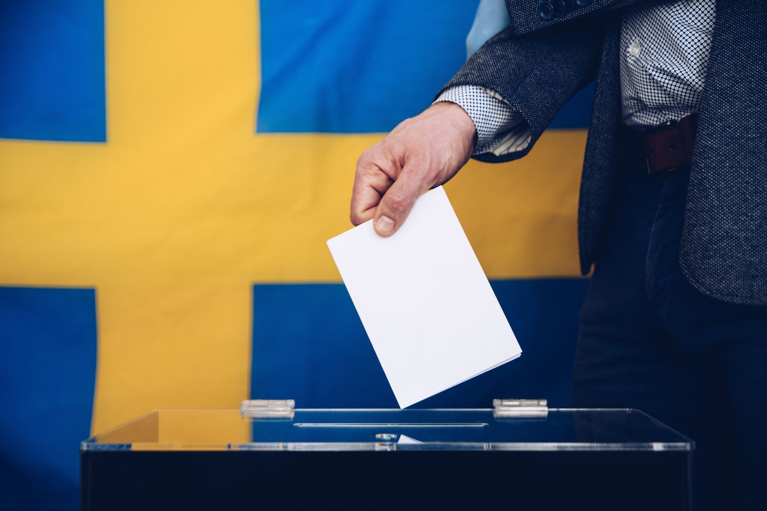 En person lägger en valsedel i valurna